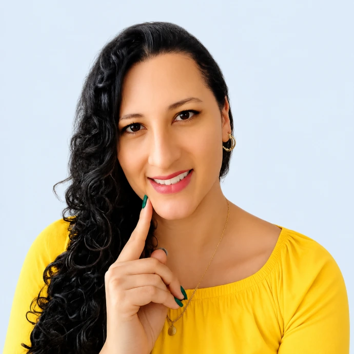 Elsa Pérez con saco amarillo, cabello rizado y sonrisa, en un retrato profesional de A Soltar La Lengua.